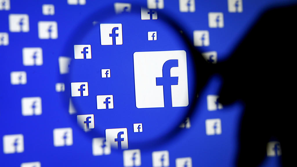 FILE PHOTO: A man poses with a magnifier in front of a Facebook logo on display in this illustration taken in Sarajevo, Bosnia and Herzegovina, December 16, 2015. REUTERS/Dado Ruvic/Illustration/File Photo