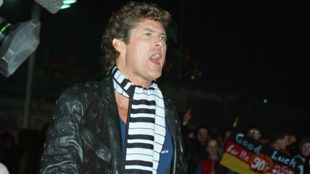 Der amerikanische Schauspieler und Sänger David Hasselhoff singt für die Berliner das Lied " Looking for Freedom" von einer Hebebühne aus bei der ersten deutsch-deutschen Silvesterfeier am Brandenburger Tor. Aufnahme vom 31.12.1989. Foto: Hermann Jos