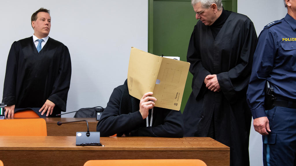 München: Der wegen versuchten Mordes an zahlreichen Frauen und Mädchen 30-jährige Angeklagte kommt vor Prozessbeginn im Landgericht zusammen mit seinen Anwälten in den Sitzungssaal.