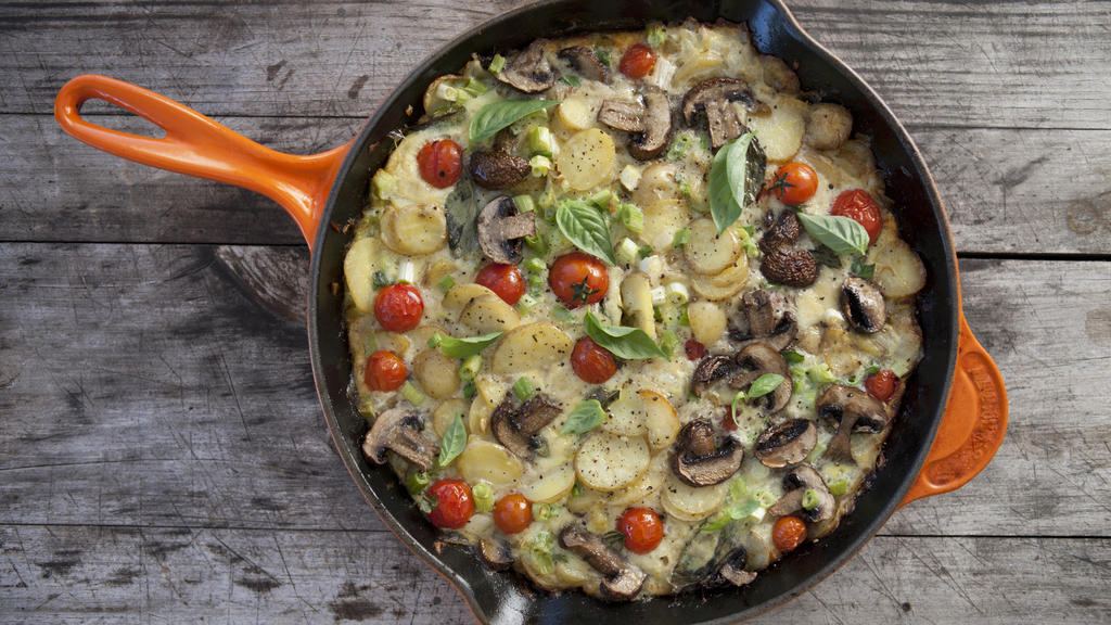 A delicious Spanish Omelette displayed on a wooden background.