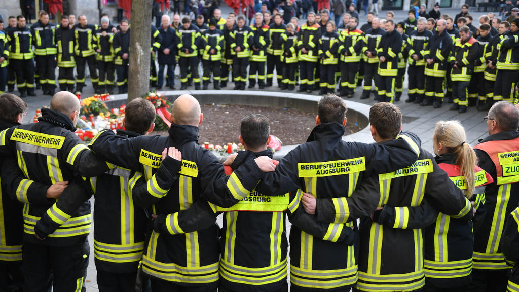 dpatopbilder - 08.12.2019, Bayern, Augsburg: Am Königsplatz trauern Feuerwehrmänner. Ein Feuerwehrmann war am Abend des 06.12.2019 in seiner Freizeit hier in einer Auseinandersetzung mit einer Gruppe so schwer verletzt worden, dass er starb. Foto: St