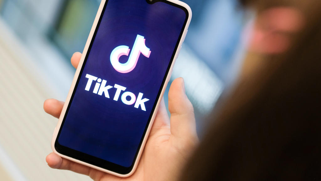 ILLUSTRATION - 13.11.2019, Berlin: ILLUSTRATION - Ein Mädchen hält ihr Smartphone in den Händen, auf dem sie ein Foto der Kurzvideo-App TikTok geöffnet hat. Mit TikTok können Nutzerinnen und Nutzer kurze Handyvideos zu Musik oder zu anderen Videos er