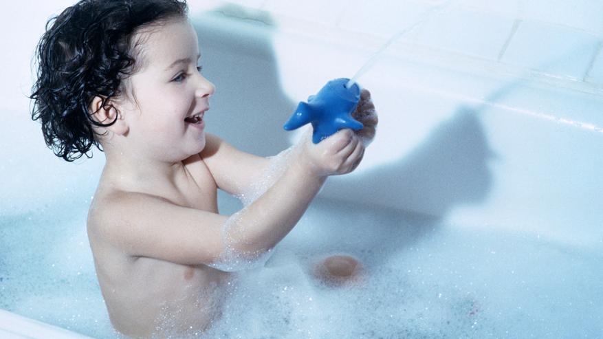 Ein Kind sitzt in der Badewanne.