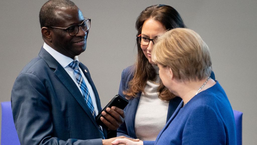 Angela Merkel, Karamba Diaby und Yasmin Fahimi unterhalten sich im Bundestag
