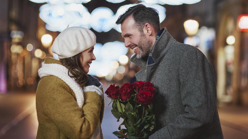 Man gifting his girlfriend bunch of red roses on Valentine s Day model released Symbolfoto PUBLICATIONxINxGERxSUIxAUTxHUNxONLY ABIF01150