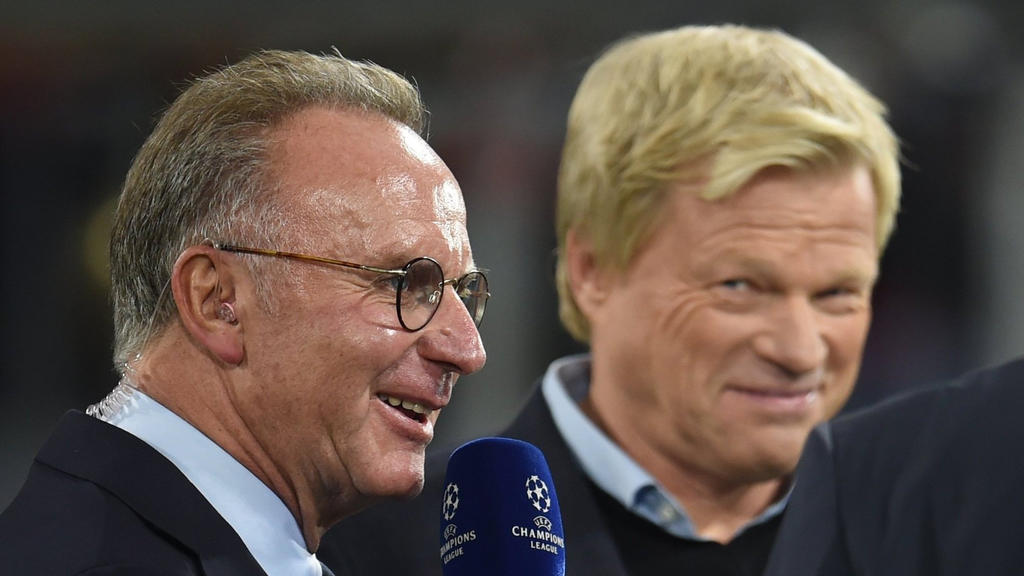 ARCHIV - 18.10.2017, Bayern, München: Karl-Heinz Rummenigge (l), Vorstandsvorsitzender des FC Bayern München, spricht mit Journalisten vor dem Champions-League-Spiel Bayern München gegen Celtic Glasgow, während im Hintergrund Oliver Kahn steht. Rumme