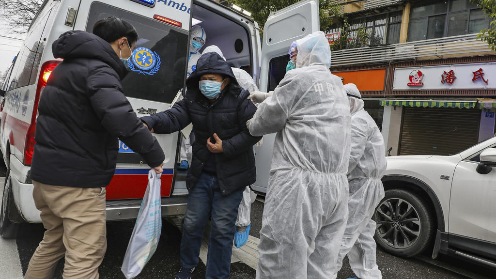 26.01.2020, China, Wuhan: Krankenhausmitarbeiter in Schutzkleidung helfen einem Patienten aus einem Krankenwagen. Angesichts der starken Ausbreitung der neuen Lungenkrankheit hat China seine Maßnahmen am Wochenende deutlich verschärft. Foto: Uncredit