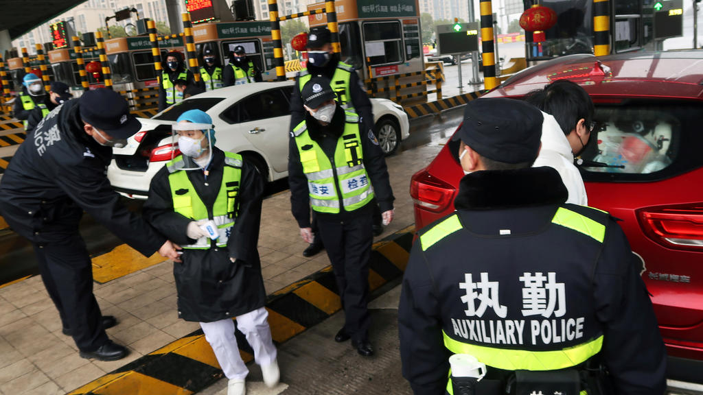 FILE PHOTO: Police officers wearing masks check the boot of a car for smuggled wild animals following the outbreak of a new coronavirus, at an expressway toll station on the eve of the Chinese Lunar New Year celebrations, in Xianning, a city borderin
