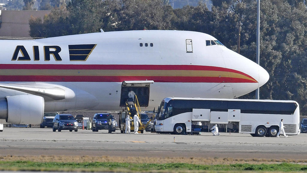January 29, 2020, Riverside, California, USA: A team in white biohazard suits unload luggage off a charter flight from Wuhan, China, carrying approximately 200 U.S. citizens, after landing at March Air Reserve Base in Riverside, Calif. Wednesday morn