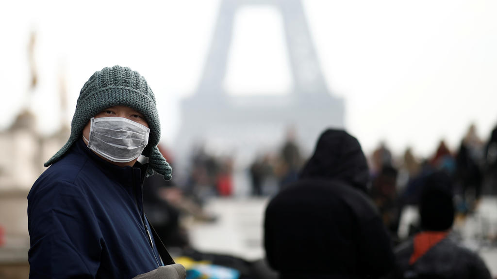 A man wears a face mask on the Trocadero esplanade in front of the Eiffel Tower in Paris, France, January 25, 2020, as France confirmed three cases of the new coronavirus. REUTERS/Benoit Tessier