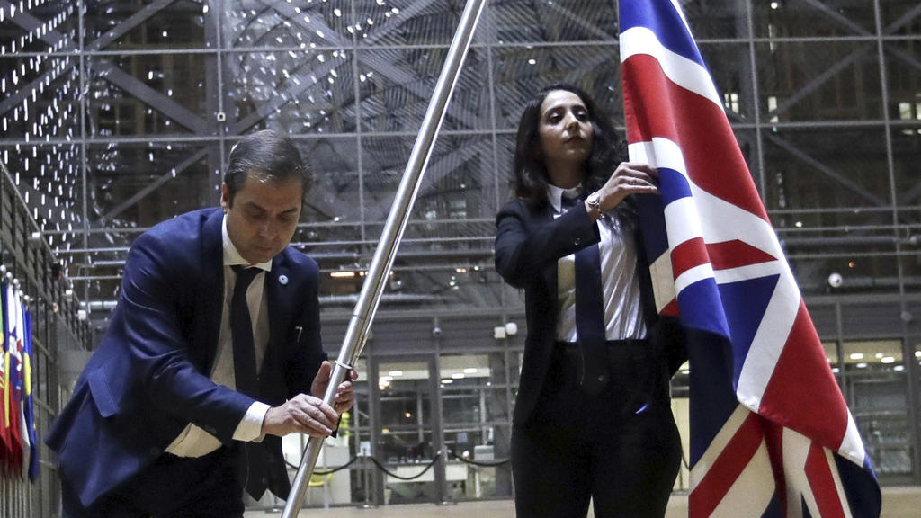 31.01.2020, Belgien, Brüssel: Mitglieder des Protokolls entfernen die Flagge des Vereinigten Königreichs aus dem Atrium des Europagebäudes. Mehr als dreieinhalb Jahre nach dem Brexit-Referendum ist Großbritannien ab dem 31.01.2020 (24 Uhr MEZ) kein M