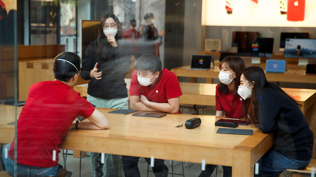 People wear face masks as they listen to a presentation in an Apple Store in the Sanlitun shopping district in Beijing as China is hit by an outbreak of the new coronavirus, January 25, 2020. Picture taken January 25, 2020. REUTERS/Thomas Peter