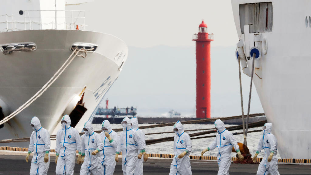 Men wearing protective gear are seen near the cruise ship Diamond Princess, where 10 more people were tested positive for coronavirus on Thursday, at Daikoku Pier Cruise Terminal in Yokohama, south of Tokyo, Japan February 7, 2020. REUTERS/Kim Kyung-