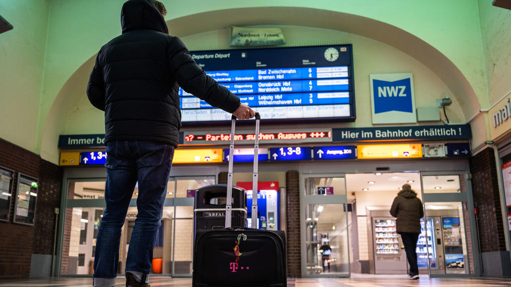 10.02.2020, Niedersachsen, Oldenburg: Ein Reisender steht am frühen Morgen im Oldenburger Hauptbahnhof und schauet zur Anzeigetafel der Deutschen Bahn hoch, auf der wegen den Folgen des Sturmtiefs ·Sabine· Verspätungen und Ausfälle der Züge angezeigt