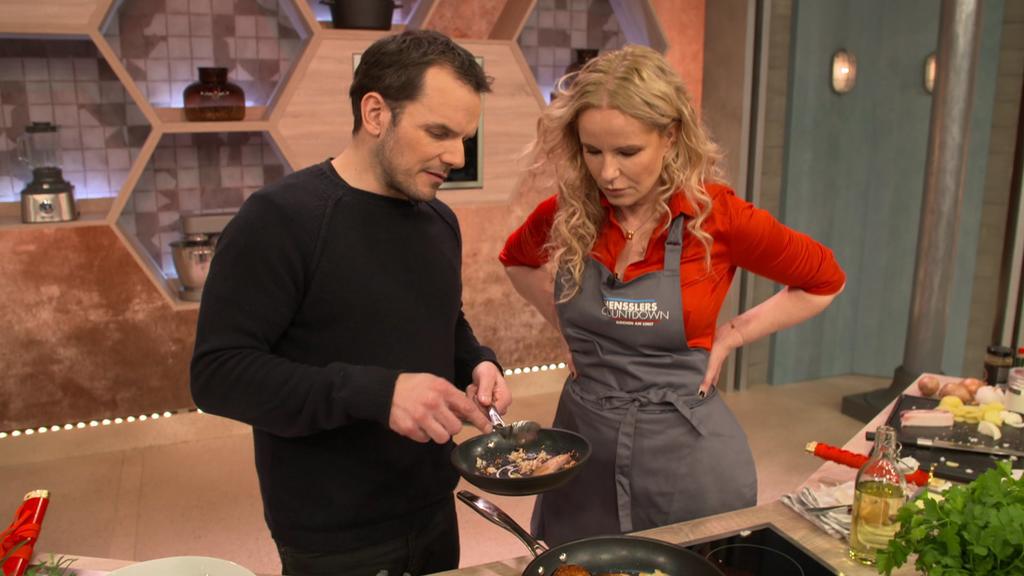 Steffen Henssler zeigt Moderatorin Katja Burkard, wie er Bratkartoffeln und Chili con Carne zubereitet.
