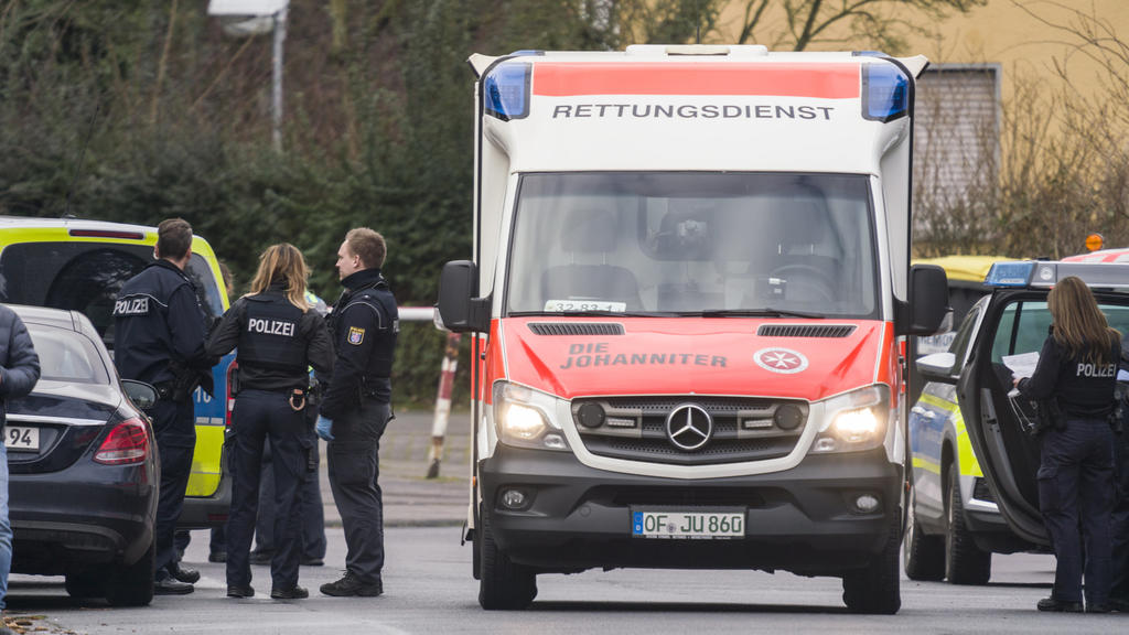 14.02.2020, Hessen, Obertshausen: Ein Rettungswagen, Polizisten und deren Fahrzeuge stehen in der Maingaustraße. Zuvor waren hier zwei Menschen durch Schüsse schwer verletzt worden. Der mutmaßliche Täter sei in seiner Wohnung vorläufig festgenommen w