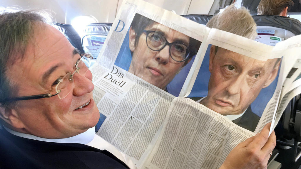 ARCHIV - 04.11.2018, Düsseldorf: Armin Laschet (CDU), Ministerpräsident von Nordrhein-Westfalen, schaut während des Flugs von Düsseldorf nach Berlin in eine aufgeschlagene Zeitung mit den Fotos von Annegret Kramp-Karrenbauer und Friedrich Merz. (zu d