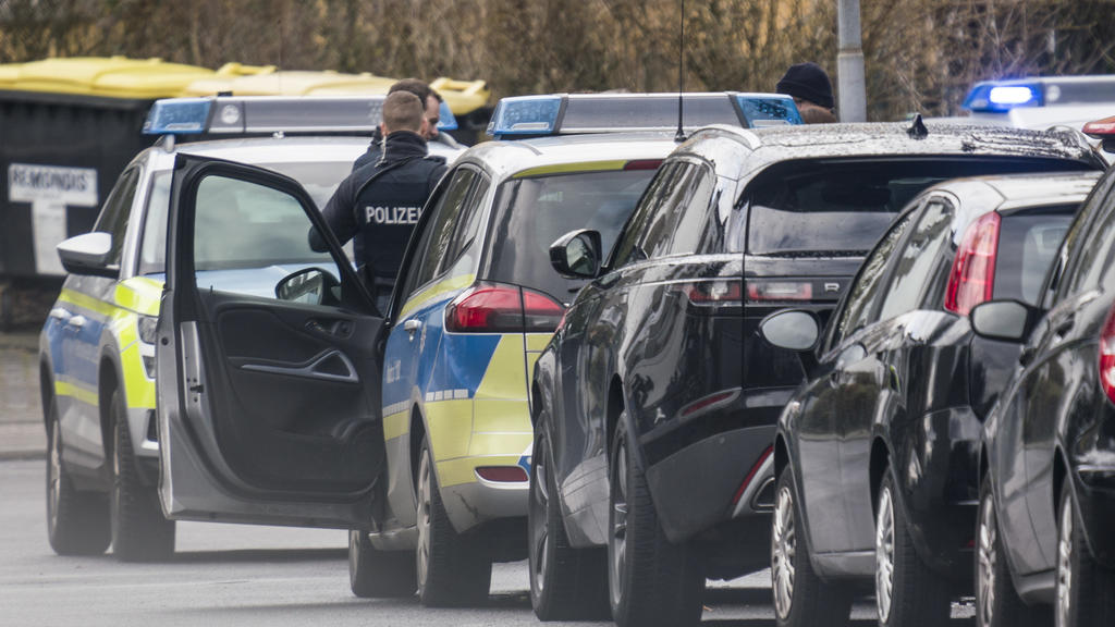 14.02.2020, Hessen, Obertshausen: Polizisten und deren Fahrzeuge stehen in der Maingaustraße. Zuvor waren hier zwei Menschen durch Schüsse schwer verletzt worden. Der mutmaßliche Täter sei in seiner Wohnung vorläufig festgenommen worden, teilte die P