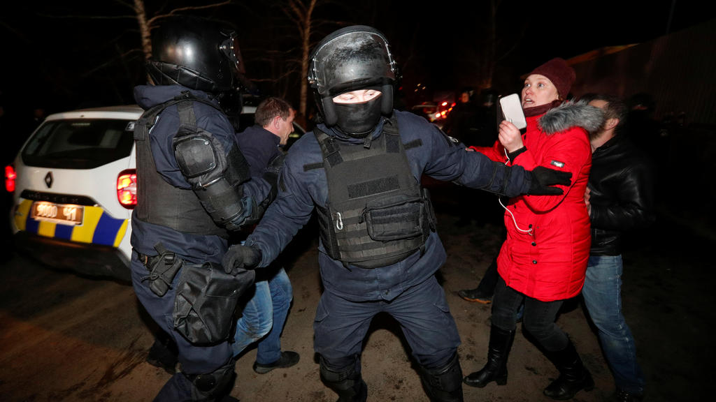 Ukrainian law enforcement officers clear the way as demonstrators attempt to block a road during a protest against the arrival of a plane carrying evacuees from coronavirus-hit China's Hubei province in the village of Novi Sanzhary in Poltava region,