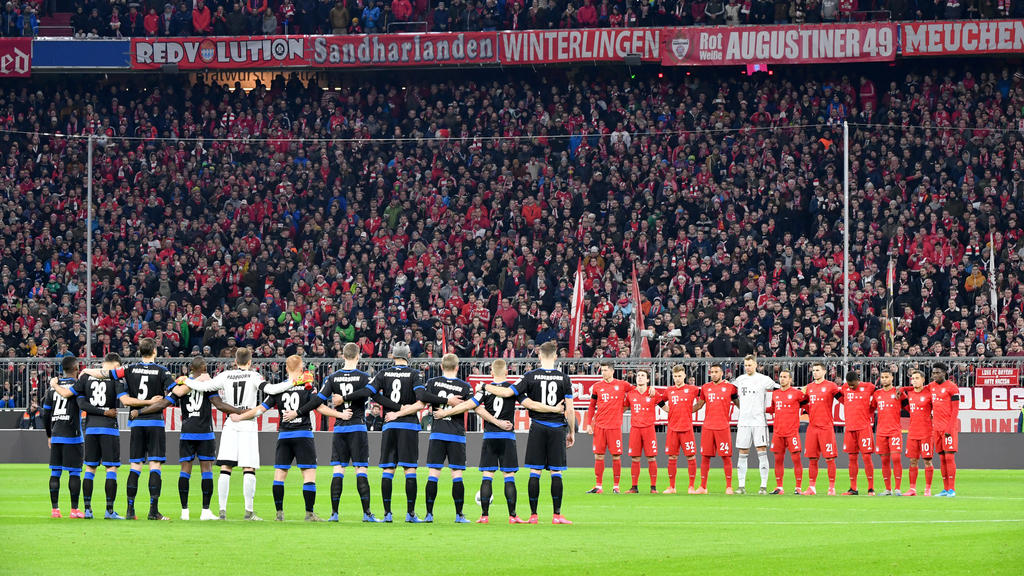 21.02.2020, Bayern, München: Fußball: Bundesliga, Bayern München - SC Paderborn 07, 23. Spieltag in der Allianz Arena. Die Mannschaften von FC Bayern München und SC Paderborn 07 stehen während einer Schweigeminute für die Terroropfer aus Hanau zusamm