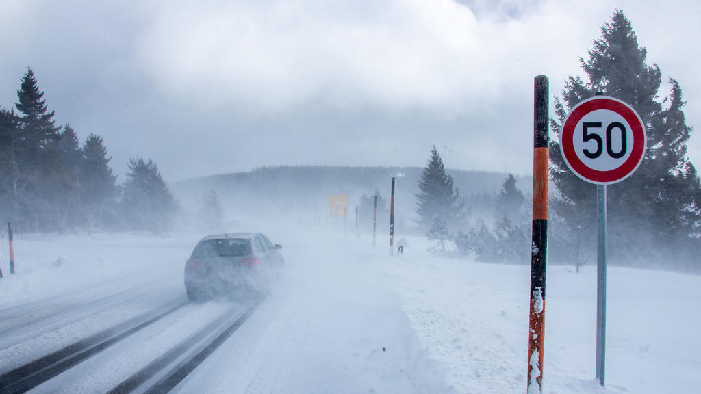 11.02.2020, Sachsen, Oberwiesenthal: Autos fahren durch vom Wind aufgewirbelte Schneewolken auf der Zufahrtsstraße zum Fichtelberg. Ausläufer von Sturmtief "Sabine" sorgen noch immer für starken Wind auf den Bergen. Wolkenlücken bringen aber auch kur