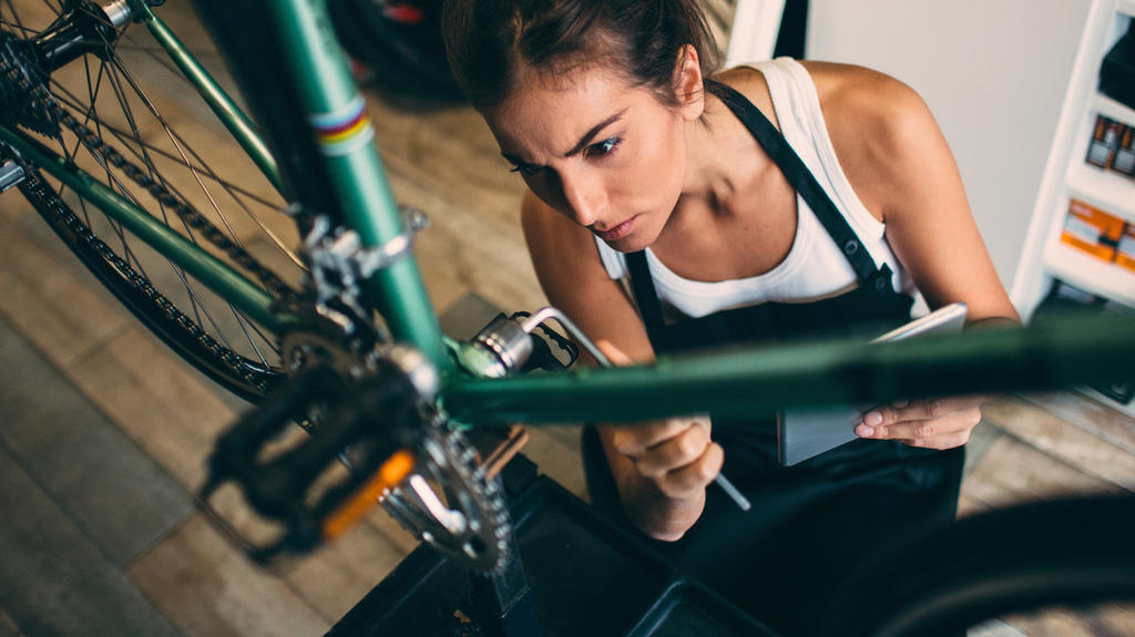 Frau macht Fahrrad fit für den Frühling