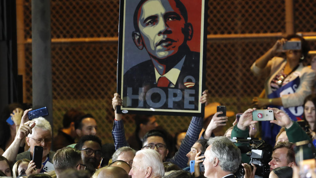 A supporters holds up a "HOPE" poster of former President Barack Obama as Democratic U.S. presidential candidate and former Vice President Joe Biden greets members of the crowd after speaking at his Super Tuesday night rally in Los Angeles, Californi