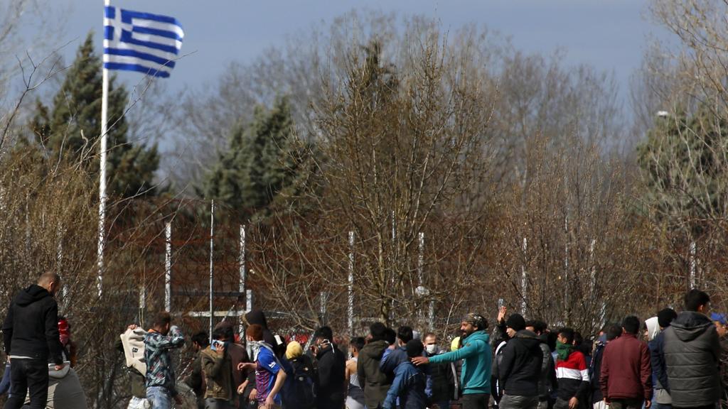 07.03.2020, Türkei, Pazarkule: Migranten stehen auf türkischer Seite vor dem Grenzzaun zu Griechenland. Tausende von Flüchtlingen und anderen Migranten haben in der vergangenen Woche versucht, in das EU-Mitglied Griechenland zu gelangen, nachdem die