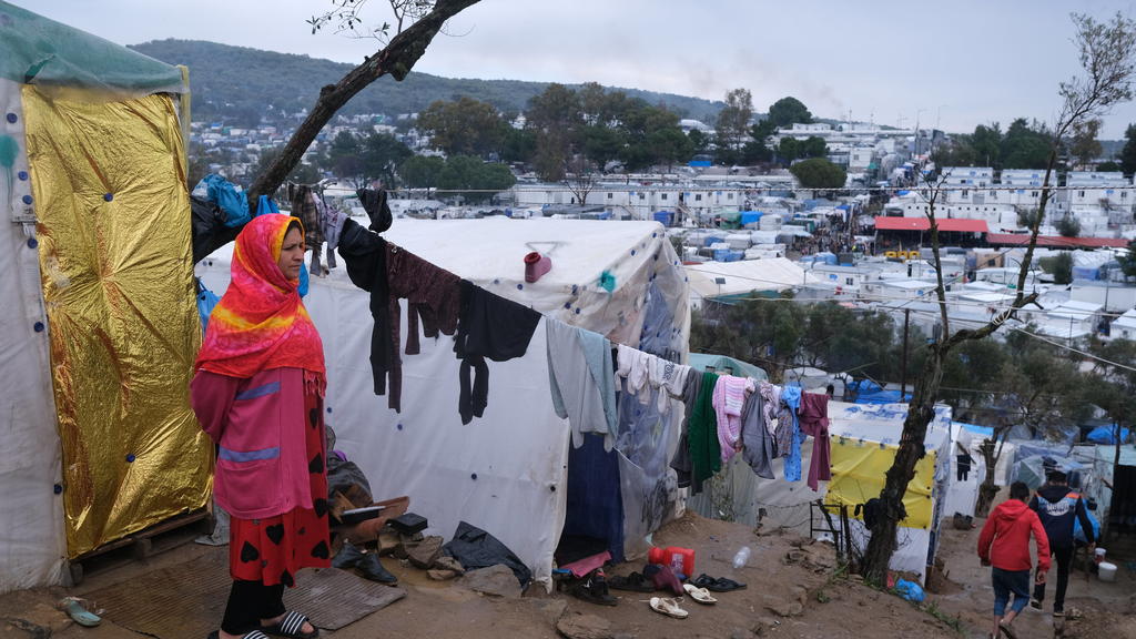 A migrant stands next to their makeshift tent outside the perimeter of the overcrowded Moria refugee camp on the northeastern Aegean island of Lesbos, Greece, Wednesday, March 11, 2020. Camps on Lesbos and other islands of the eastern Aegean are alre