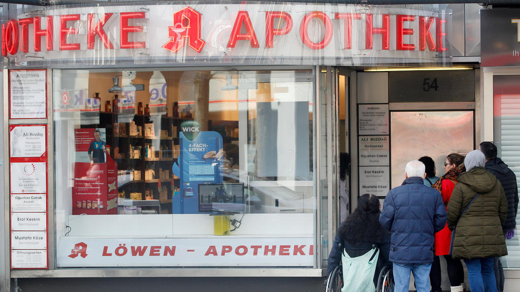 16.03.2020, Nordrhein-Westfalen, Duisburg: Vor der Eingangstüre einer Apotheke hat sich eine Menschenschlange gebildet, weil nur noch jeweils ein Kunde die Apotheke betreten darf. So soll die Ansteckungsgefahr für die Kunden und die Apothekenmitarbei