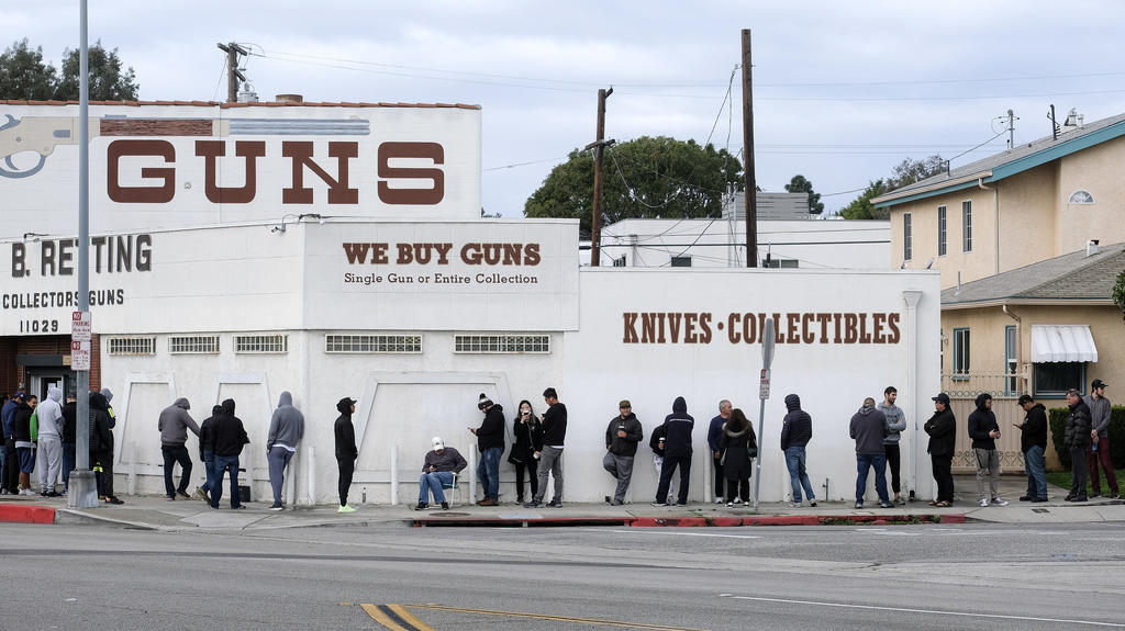 15/03/2020, États-Unis, Culver City: les gens attendent dans une longue file devant un magasin d'armes à feu en période de propagation rapide du nouveau type de virus corona dans le pays. Certaines personnes attendent de s'approvisionner en munitions, tandis que d'autres disent qu'elles vont à W