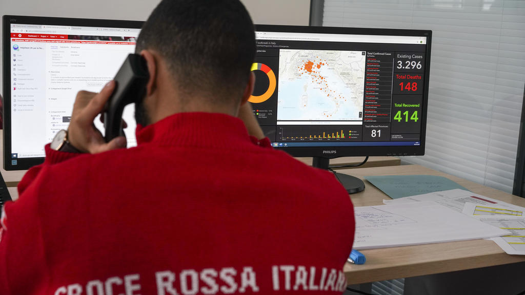06.03.2020, Italien, Rom: Mitarbeiter des Roten Kreuzes bereiten sich bei einer Übung auf den Transport eines Coronavirus-Patienten vor. Die Zahl der Coronavirus-Infizierten und der Toten in Italien steigt trotz umfangreicher Gegenmaßnahmen stetig an
