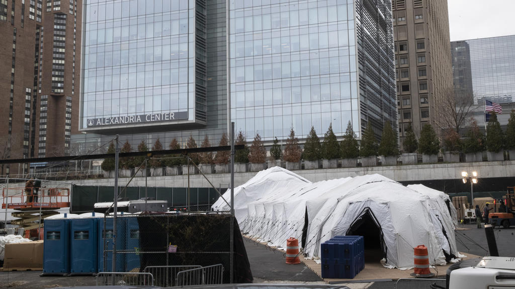 25.03.2020, USA, New York: Ein Zelt, das als behelfsmäßige Leichenhalle genutzt werden soll, wird gebaut. Foto: Mary Altaffer/AP/dpa +++ dpa-Bildfunk +++