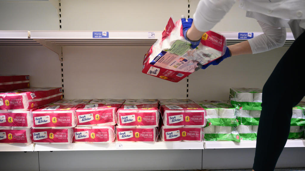 ARCHIV - 18.03.2020, Baden-Württemberg, Stuttgart: Eine Mitarbeiterin räumt in einem Drogeriemarkt der Kette dm-drogerie markt Toilettenpapier ein. Aufgrund der Ausbreitung des Coronaviruses kaufen Kunden momentan stärker ein. (zu dpa: «Drogeriemarkt
