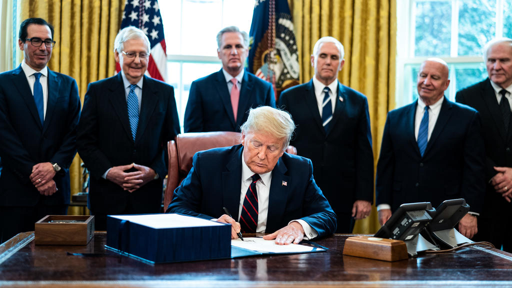 United States President Donald J. Trump participates in a signing ceremony for a two trillion dollar coronavirus relief bill in the Oval Office at the White House in Washington, DC on March 27, 2020. Standing behind the President from left to right: