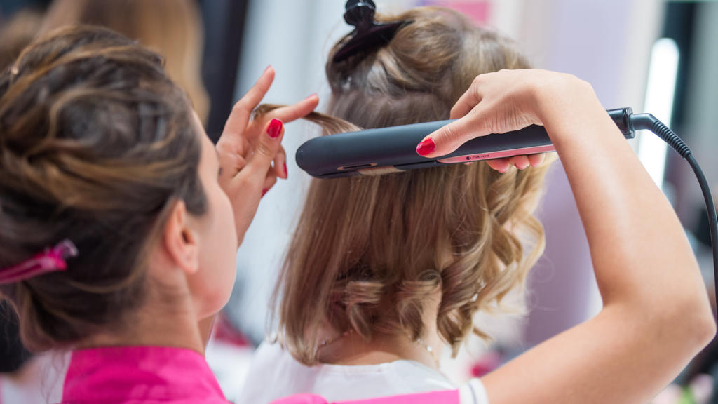 ARCHIV - 05.09.2018, Berlin: Einer Frau werden in einem Friseursalon die Haare geglättet. In einer Gesprächsrunde soll der frage nachgegangen werden, wie sich die Situation von Frauen auf dem Arbeitsmarkt in den vergangenen Jahren verändert hat (zu d