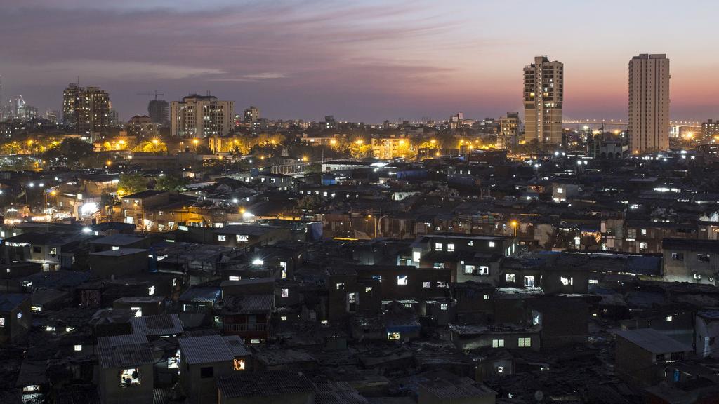 FILE PHOTO: High-rise residential towers are seen behind shanties in Dharavi, one of Asia's largest slums, in Mumbai March 18, 2015. REUTERS/Danish Siddiqui/File Photo