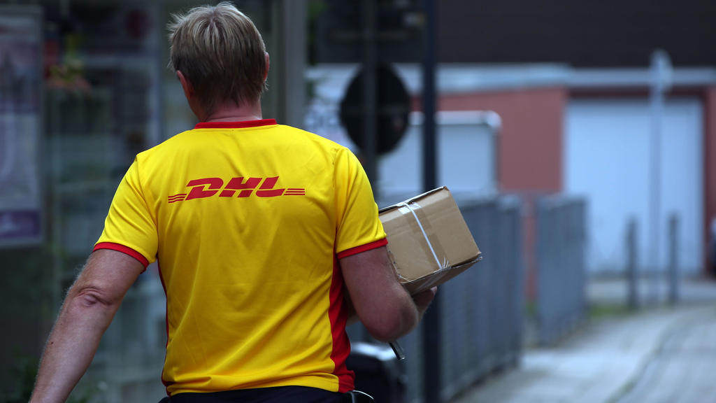 ARCHIV - 02.09.2015, Nordrhein-Westfalen, Herten: Ein Paketzustellerder von Deutsche Post DHL liefert ein Paket aus. (Zu dpa «Deutsche Post bereitet Einschränkungen wegen Corona-Pandemie vor») Foto: picture alliance / dpa +++ dpa-Bildfunk +++