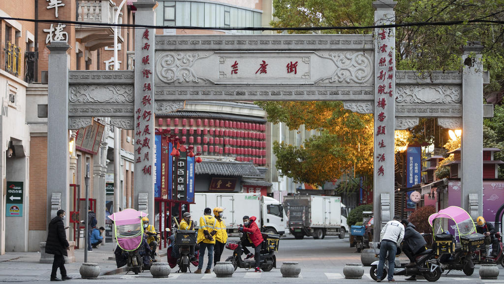 01.04.2020, China, Wuhan: Lieferanten warten auf einer Straße auf Bestellungen. In der Millionenmetropole, in der Ende 2019 erste Fälle des bis dahin unbekannten Coronavirus auftraten, fließt allmählich wieder der Verkehr. Foto: Fei Maohua/XinHua/dpa