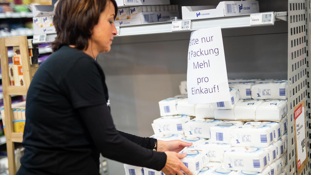 02.04.2020, Nordrhein-Westfalen, Gangelt-Birgden: Claudia Karl, Rewe-Mitarbeiterin, packt im Rewe Einkaufsmarkt Schmitz Lebensmittel in eine Postbox. Im besonders vom Coronavirus betroffenen Kreis Heinsberg startet die Deutsche Post ein Pilotprojekt