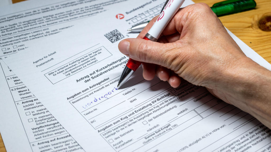 ARCHIV - 30.03.2020, Mecklenburg-Vorpommern, Schwerin: ILLUSTRATION - Eine Frau füllt ein Antragsformular für Kurzarbeitergeld aus. Durch das Instrument der Kurzarbeit wird der von der Corona-Pandemie verursachte Wirtschaftseinbruch einer Auswertung