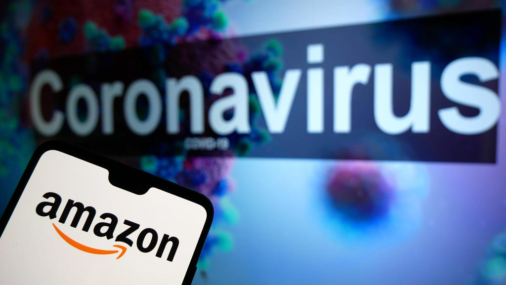 Coronavirus Stock The Amazon logo seen displayed on a mobile phone with an illustrative model of the Coronavirus displayed on a monitor in the background. Photo credit should read: James Warwick/EMPICS Entertainment PUBLICATIONxINxGERxSUIxAUTxONLY C