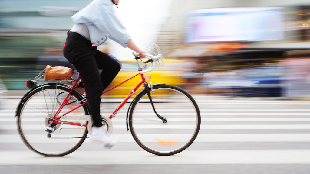 Fahrradfahrer fährt über Zebrastreifen.