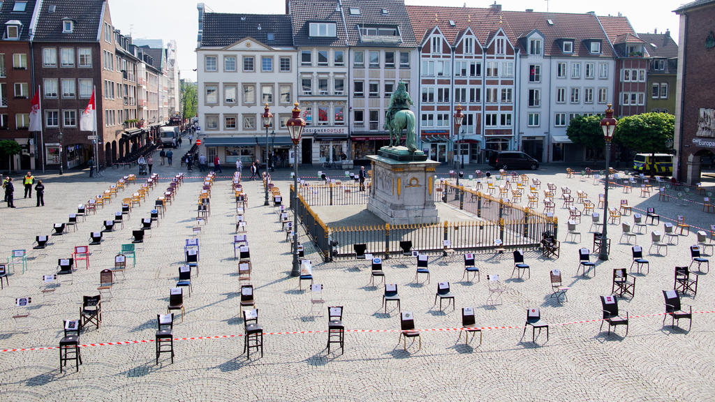 24.04.2020, Nordrhein-Westfalen, Düsseldorf: Leere Stühle stehen vor dem Rathaus und umgeben das Jan-Wellem-Denkmal. Düsseldorfer Gastronomen wollen hier mit einer Mahnwache auf ihre wirtschaftlichen Probleme aufmerksam machen. Foto: Rolf Vennenbernd