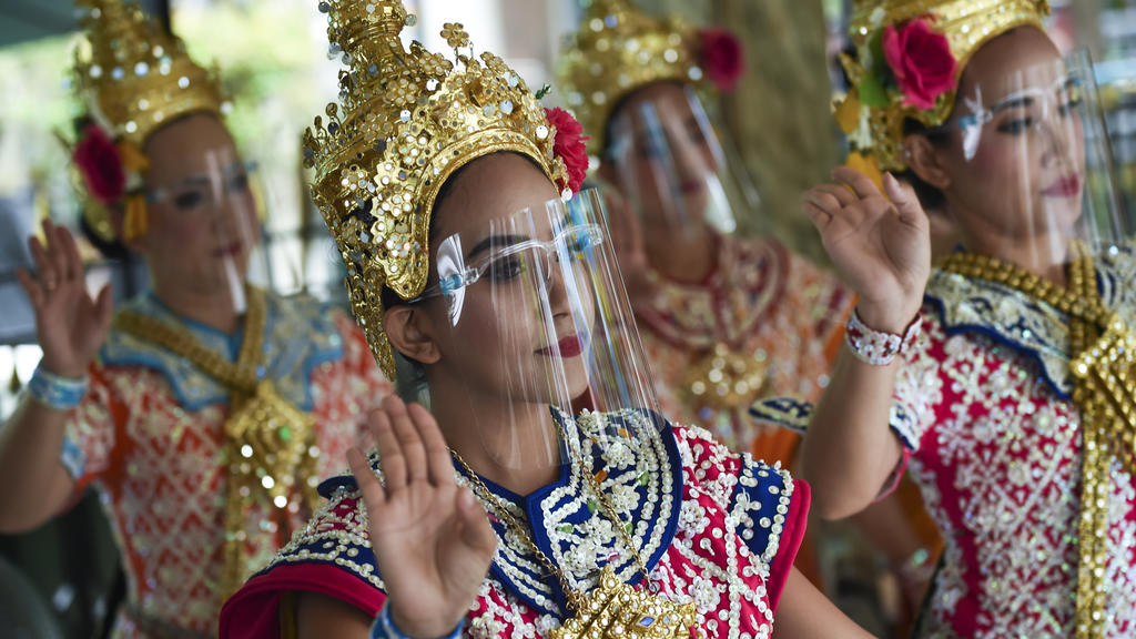 In the Thai capital Bangkok women dance with face protection.