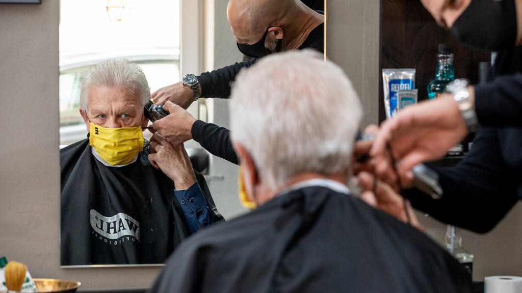 BROCHURE - 04.05.2020, Baden-Württemberg, Stuttgart: Winfried Kretschmann (Bündnis 90 / Die Grünen), Prime Minister of Baden-Württemberg, cuts his hair with barber Giovanni Dell Aquila. On Monday, the hairdressers were allowed na