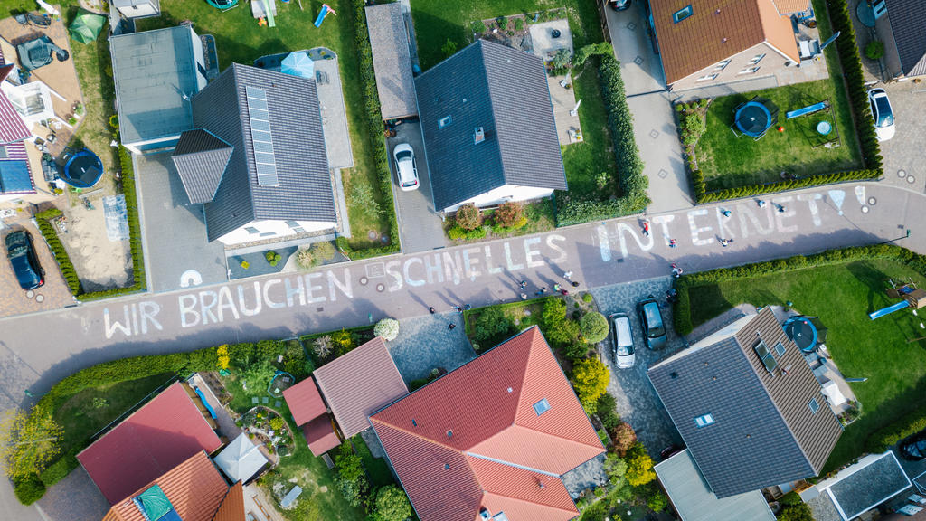 dpatopbilder - 05.05.2020, Niedersachsen, Weetzen: "Wir brauchen schnelles Internet!!" steht in großen Buchstaben aus Kreide im Wohngebiet Altes Bergfeld. (Aufnahme mit Drohne) Die Anwohner wollen mit der Aktion auf ihre langsame Internetverbindung a