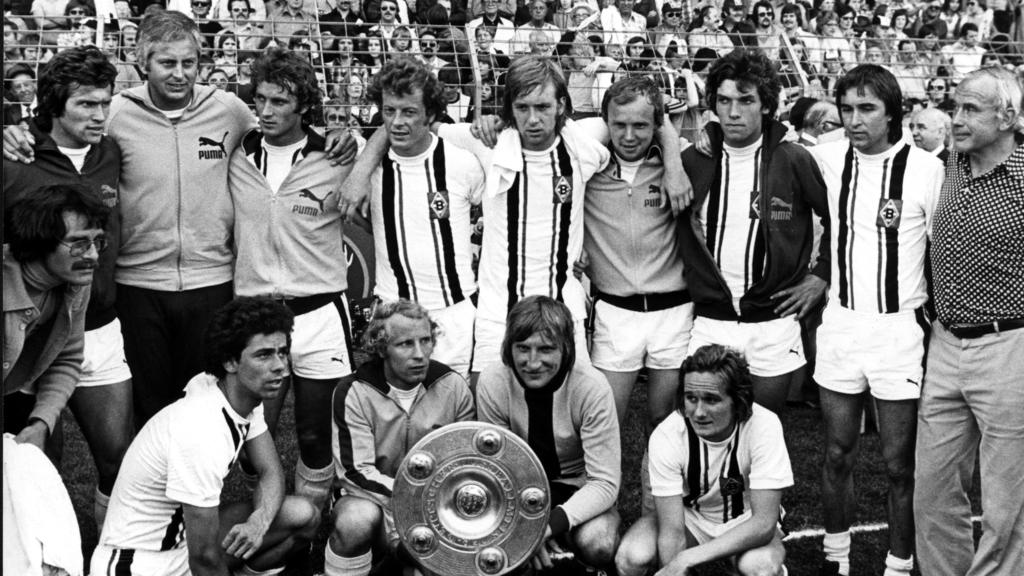 ARCHIV - 07.06.1975, Nordrhein-Westfalen, Mönchengladbach: Gruppenbild des Deutschen Meisters Borussia Mönchengladbach nach dem Sieg am vorletzten Spieltag der Bundesliga gegen Eintracht Braunschweig in Mönchengladbach. (Stehend v.l.n.r) Jupp Heyncke