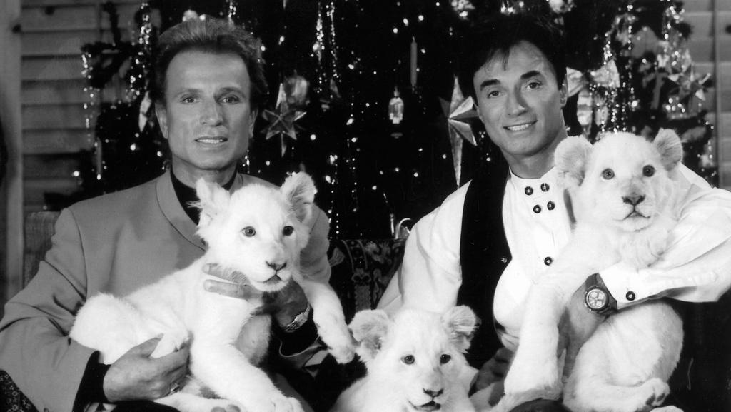 ARCHIV - 30.11.1999, USA, Las Vegas: Die deutschen Magier Siegfried (l) und Roy sitzen im Dezember 1999 in Las Vegas (USA) vor einem Weihnachtsbaum. «Siegfried & Roy»-Magier Roy Horn ist in Las Vegas an den Folgen von Covid-19 gestorben. Foto: Fotore