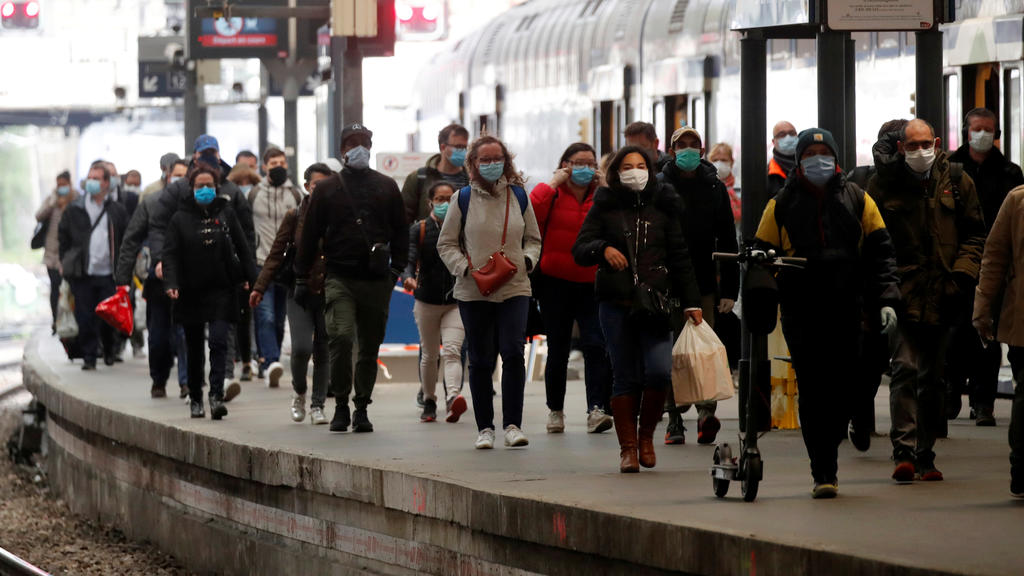 Commuters, who wear protective face masks, walk on a platform at the Saint-Lazare train station in Paris, the first day the use of masks is compulsory on public transport, after France began a gradual end to a blockade national due to coronavirus di